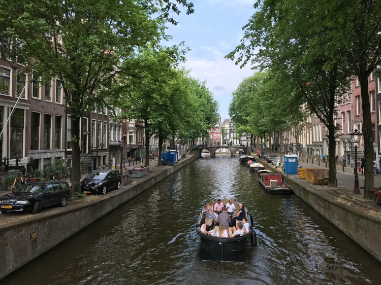 Boat going down a canal in Amsterdam